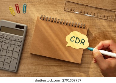 Eye-catching image of CDR text on stickynote. The word stands for Carbon Dioxide Removal. Shown with calculator, ruler, pen.
