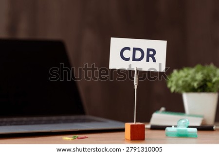 Eye-catching image of CDR text on card. The word stands for Carbon Dioxide Removal. Shown with laptop, clips.