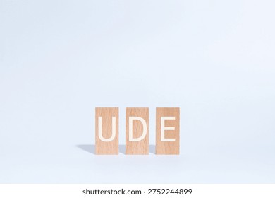 Eye-catching image of UDE text on wood blocks. The word stands for Undesirable Effect.