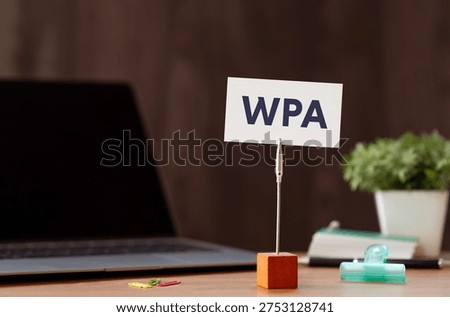 Eye-catching image of WPA text on card. The word stands for Wi-Fi Protected Access. Shown with laptop, clips.
