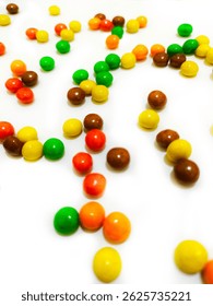 Eye-catching multicolor candy balls spread across a white surface, ideal for food styling or fun visual backgrounds.