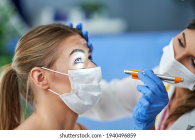 Eye-doctor in mask checking up on female patient - Powered by Shutterstock