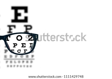 Eyeglasses with blurred optician visual text chart on a white background. 