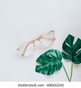 Eyeglasses And Green Palm Leaves On Grey Background, Minimal Style With Spring And Fashion Accessory Concept