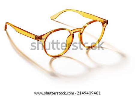 Eyeglasses in orange golden bright color in transparent plastic. Eyewear side view with shadow. Trendy glasses isolated on white background. Fashion spectacles for man and woman