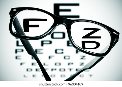 Eyeglasses Over A Blurry Eye Chart