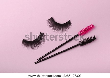 Eyelash extension brushes on a lilac background. Brush for combing extended and false eyelashes. Brush for straightening eyelashes and eyebrows.