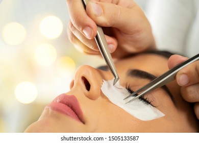 Eyelash Extension Closeup, Hand With Tweezers Holding Silk Eyelashes 