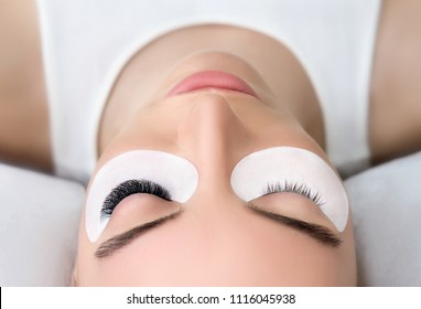 Eyelash Extension Procedure.  Beauty Model with  Perfect Fresh Skin and Long Eyelashes. Slincare, Spa and Wellness. Make up,  Hair and Lashes. Close up.