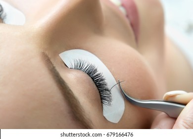 Eyelash Extension Procedure.  Beauty Model with  Perfect Fresh Skin and Long Eyelashes. Skincare, Spa and Wellness. Make up,  Hair and Lashes. Close up.
