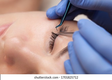 Eyelash extension procedure close up. Beautiful woman with long eyelashes in a beauty salon. Makeup concept - Shutterstock ID 1701825712