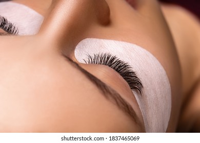 Eyelash Extension Procedure. Nahaufnahme des schönen weiblichen Auges mit langen Wimpern, glatter gesunder Haut.