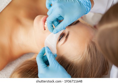 Eyelash extension procedure, a professional stylist lengthens women eyelashes.