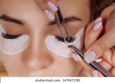 Eyelash Extension Procedure. Woman Eye with Long Blue Eyelashes. Close up, selective focus.