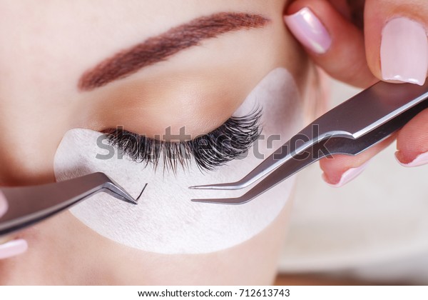 Eyelash Extension Procedure.\
Woman Eye with Long Eyelashes. Lashes, close up, macro, selective\
focus.