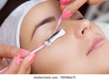 Eyelash removal procedure close up. Beautiful Woman with long lashes in a beauty salon. Eyelash extension.
