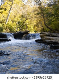 Eye-level view of a small waterfall over boulders in Big Creek or Vickery Creek in the Chattahoochee River National Recreation Area in Roswell, GA