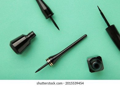 Eyeliners on mint background with copy space. Top view. Beauty concept