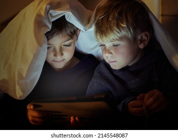 The eyes of children sees everything fresh and full of wonder. Shot of two adorable little boys using a digital tablet under a blanket fort at night in their bedroom. - Powered by Shutterstock