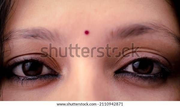 The eyes of a lady wearing\
a bindi