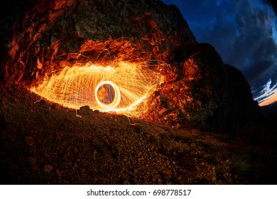 eyes are painted burning steel wool in the mountain
