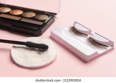 Eyeshadows, Mascara, False Eyelashes And Used Cotton Pad On Pink Background, Closeup