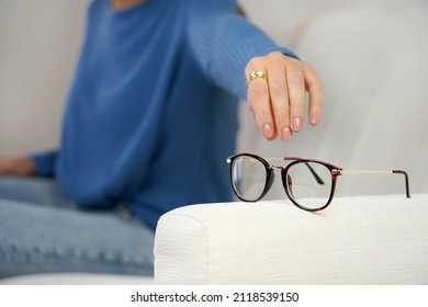 Eyesight Problem. Woman Reaching For Eyeglasses On Sofa, Having Poor Eye Sight.