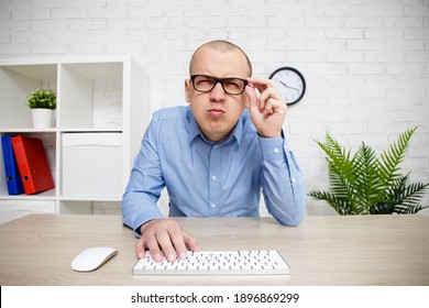 Eyevision Problems - Man Using Computer, Holding Glasses On His Face And Peering Into The Distance Trying To See Something