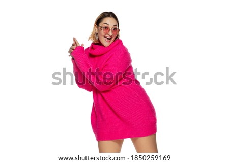Eyewear. Beautiful young woman bright pink comfortable sweater, long sleeve isolated on white studio background. Magazine style, fashion, beauty concept. Fashionable posing. Copyspace for ad.