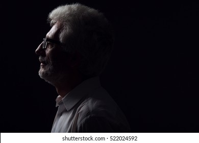 Eyewear Concept. Profile Portrait Of 60-year-old Man Standing Over Black Background. Close Up. Classic Style. Copy-space. Studio Shot