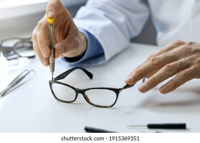 Eyewear Repair Service - Optical Technician Repairing Eyeglass Frame With Screwdriver