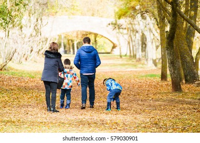 Ezcaray, La Rioja, Spain - 11.13.2016: Back View Of Family Of Four Members Walking In Autumnal Par.