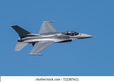 F-16 Fighting Falcon Silhouette in Clear Blue Sky with Fighter Pilot Visible