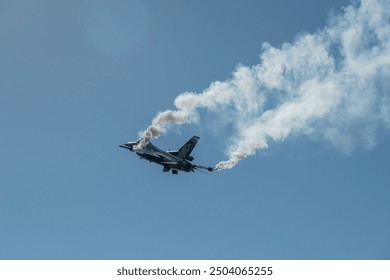 F-16 Looping A Solo Turk F-16 fighter jet performing a loop maneuver, leaving a trail of smoke in a clear blue sky.The aircraft demonstrates incredible agility and control  - Powered by Shutterstock