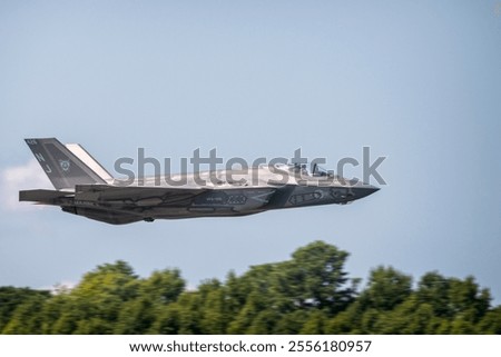 F-35 Lightning II in mid-flight, showcasing stealth design and advanced capabilities against a clear blue sky. Perfect for aviation and military enthusiasts.