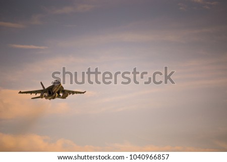 F/A-18 Super Hornet flying at sunset