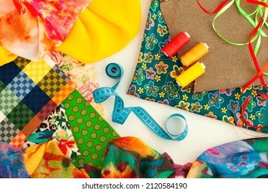 Fabric And Accessories For Sewing. Silk, Fabric, Centimeter Tape, Threads Are Gathered Together. Textiles And Sewing Trifles.