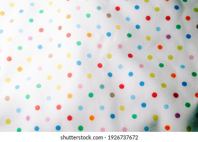 Fabric background with pattern. Rainbow balls on the fabric.