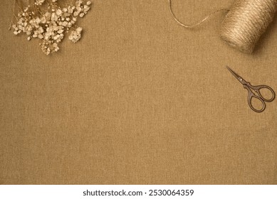 Fabric background with string, scissors and flowers from above. Vintage style. Copy space