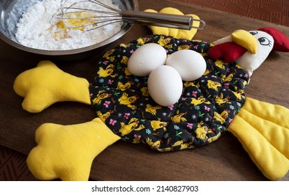 Fabric Chicken With Three Eggs On Top And Bowl With Sprinkle And Egg Yolks Mixed In The Center By A Whisk That Is Dirty With This Mixture