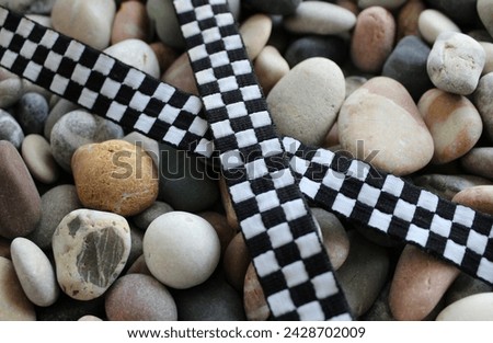 Fabric Crisscross Racing Checkered Stripe On Decorative Rocks Closeup View
