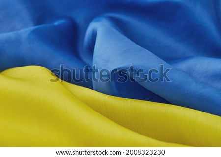 Fabric curved flag of Ukraine, UA. Blue and yellow colors. Close up shot, background
