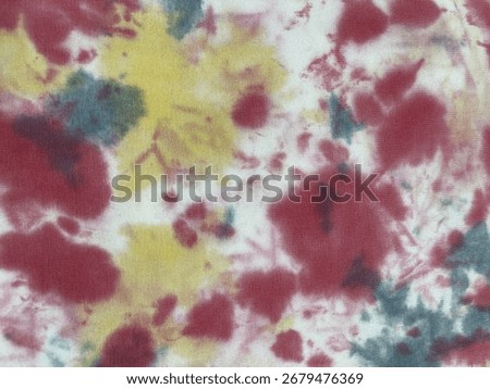 Fabric with drip dye technique using natural tea dye creating organic patterns in warm brown, red, and yellow tones with flowing, irregular color distribution