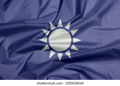 Fabric Flag Of Kuomintang. A White Sun With Twelve Rays On Blue Background.