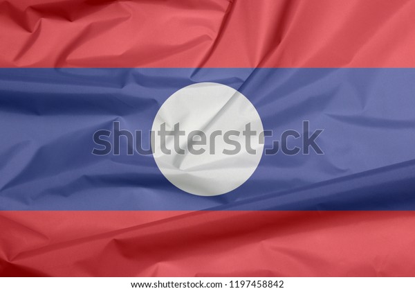 Fabric flag of Laos. Crease of Lao flag\
background, blue red and white circle\
color.