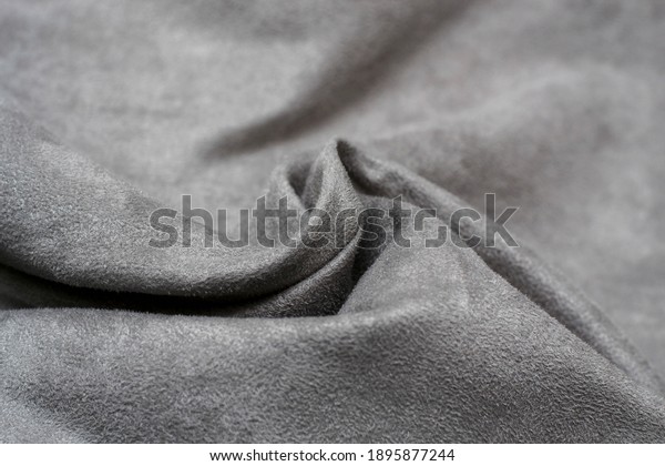 Fabric is grey suede. The texture is faux suede\
. Background of a suede\
curtain.