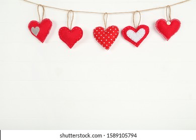 Fabric hearts hanging on white wooden background - Powered by Shutterstock