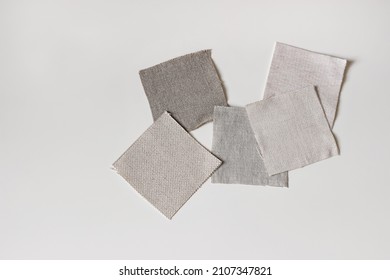 Fabric samples. Linen, cotton and velevt textile swatches isolated on white table backgound. Flat lay, top view. Neutral color palette mood board. Renovating, upholstery remodeling craft concept.
