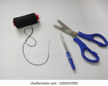 Fabric Scissors, Seam Ripper, Black Thread, Hand Sewing Needle Isolated On A White Background.