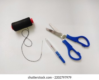 Fabric Scissors, Seam Ripper, Black Thread, Hand Sewing Needle Isolated On A White Background.